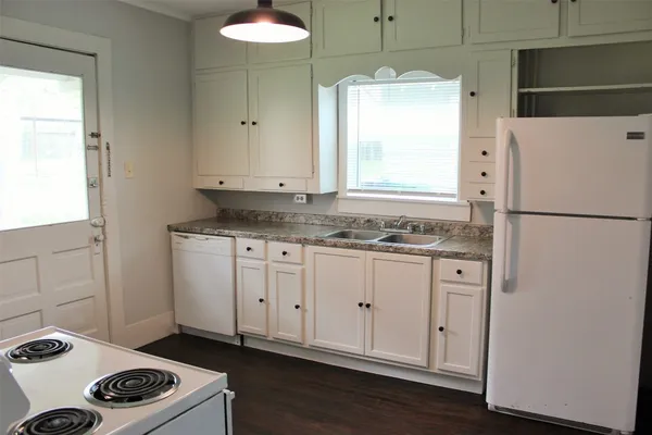 a kitchen with a refrigerator a stove a sink and a cabinets
