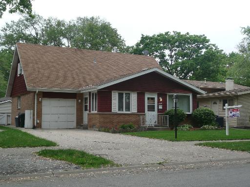 14519 South Springfield Avenue Midlothian, IL 60445 - Photo 1 of 1 a front view of a house with a garden and plants