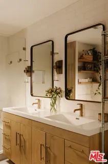 a bathroom with double vanity sinks and a mirror