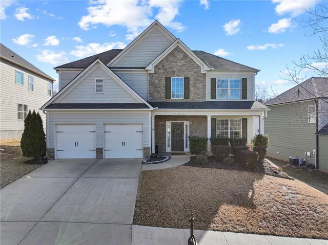 a front view of a house with a yard and outdoor seating