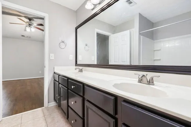 a bathroom with a double vanity sink and mirror