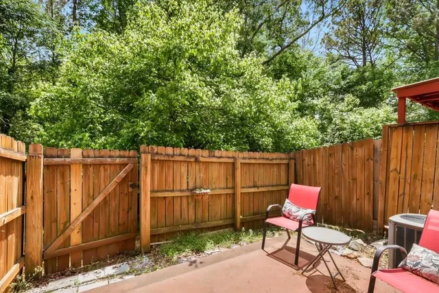 a backyard of a house with chairs and a tree