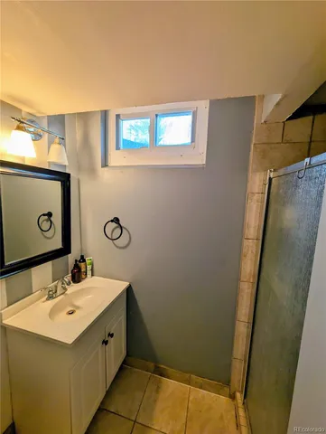 a bathroom with a sink a mirror and a shower