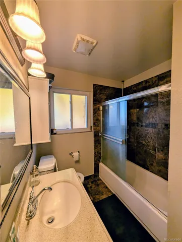 a bathroom with a tub sink and mirror