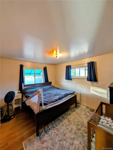 a bedroom with a bed and a flat tv screen on dresser