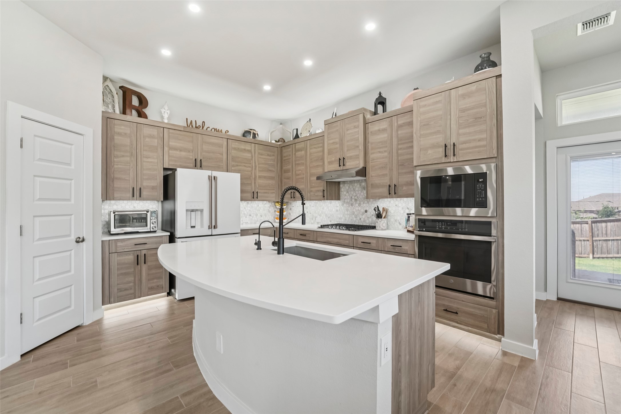 1108 Sweetspire Street Leander, TX 78641 - Photo 12 of 39 a kitchen with refrigerator cabinets and wooden floor