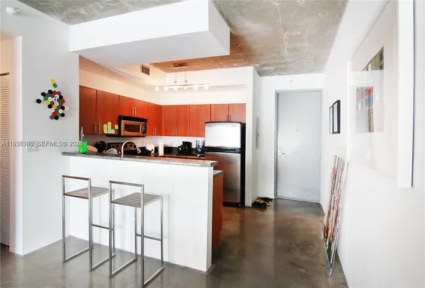 a kitchen with stainless steel appliances granite countertop a refrigerator and a stove top oven