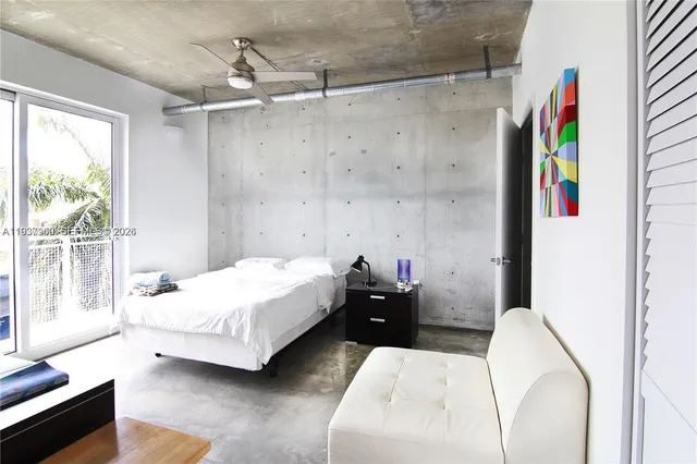 a bedroom with a bed couch and a window