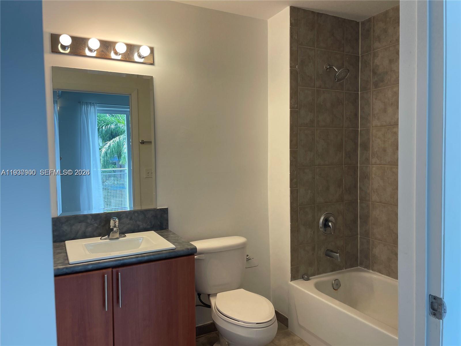 455 Northeast 25th Street, Unit 407 Miami, FL 33137 - Photo 29 of 50 a bathroom with a sink a toilet and shower