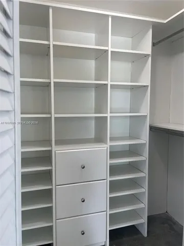 a view of walk in closet with empty racks