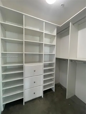 a view of walk in closet with empty racks