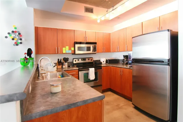 a kitchen with stainless steel appliances granite countertop a sink refrigerator and microwave