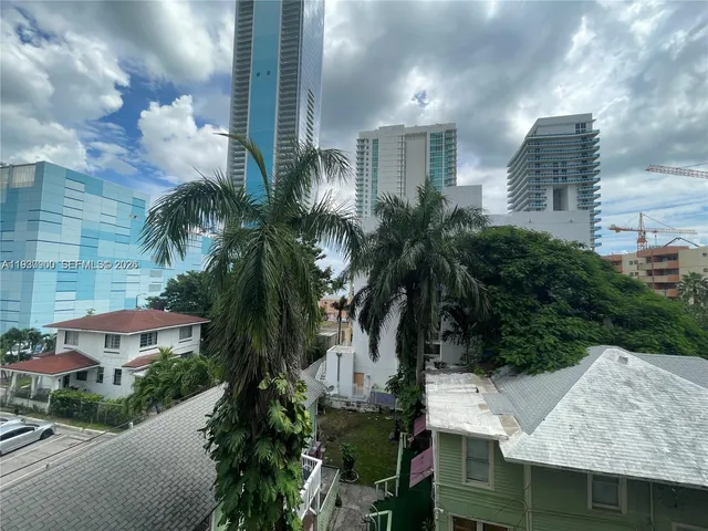 a view of residential houses with palm trees