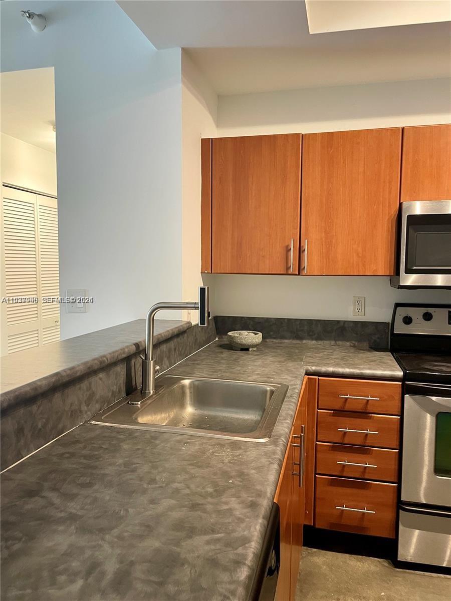 455 Northeast 25th Street, Unit 407 Miami, FL 33137 - Photo 5 of 50 a kitchen with sink a window and appliances