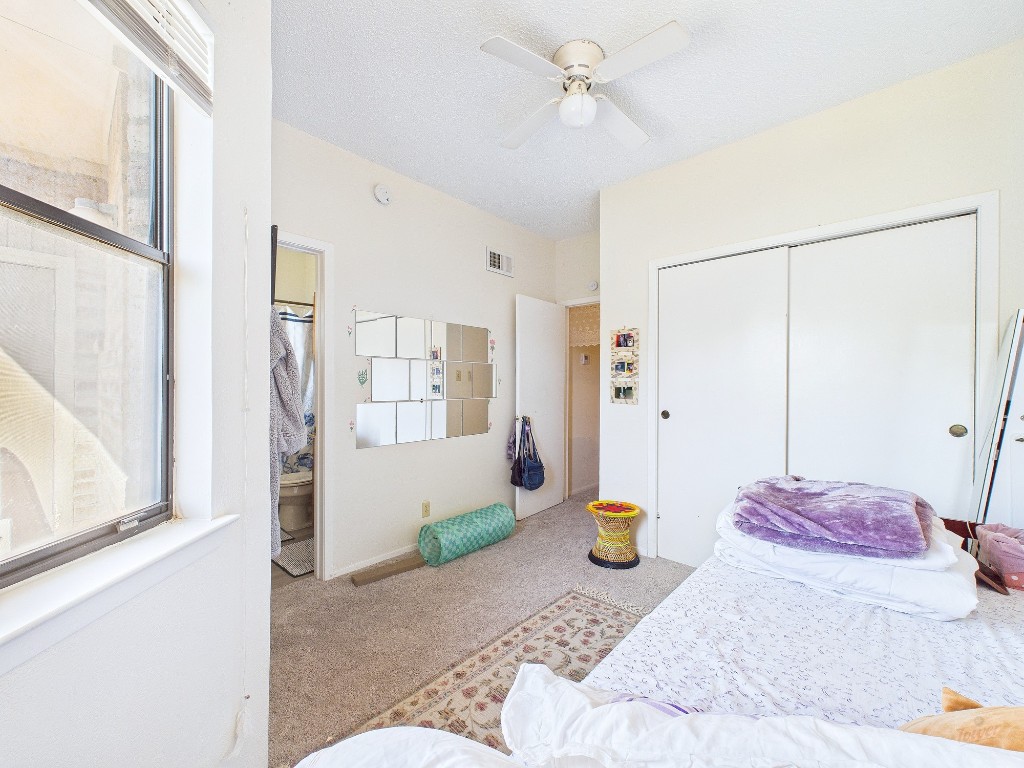3316 Guadalupe Street, Unit 321 Austin, TX 78705 - Photo 12 of 13 a bedroom with a bed and a chandelier