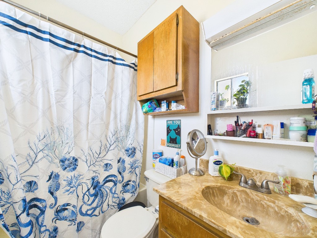 3316 Guadalupe Street, Unit 321 Austin, TX 78705 - Photo 7 of 13 a bathroom with a granite countertop sink and a toilet