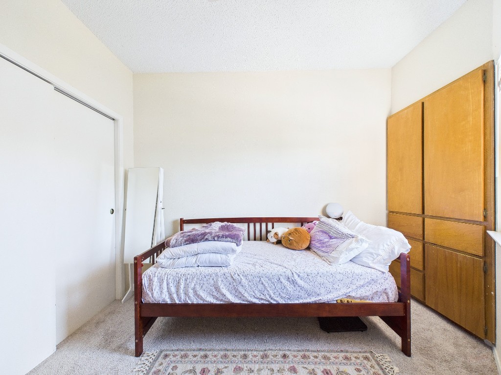 3316 Guadalupe Street, Unit 321 Austin, TX 78705 - Photo 9 of 13 a bedroom with a bed and wooden floor