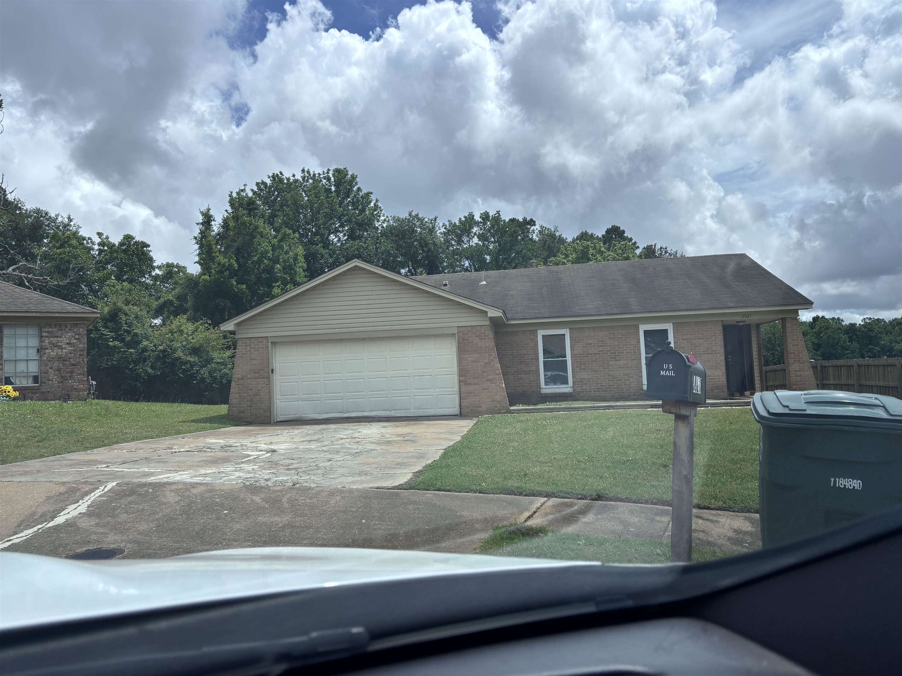 3021 Meadowfair Road Memphis, TN 38118 - Photo 1 of 3 Brick and siding exterior featuring an attached garage with a white door