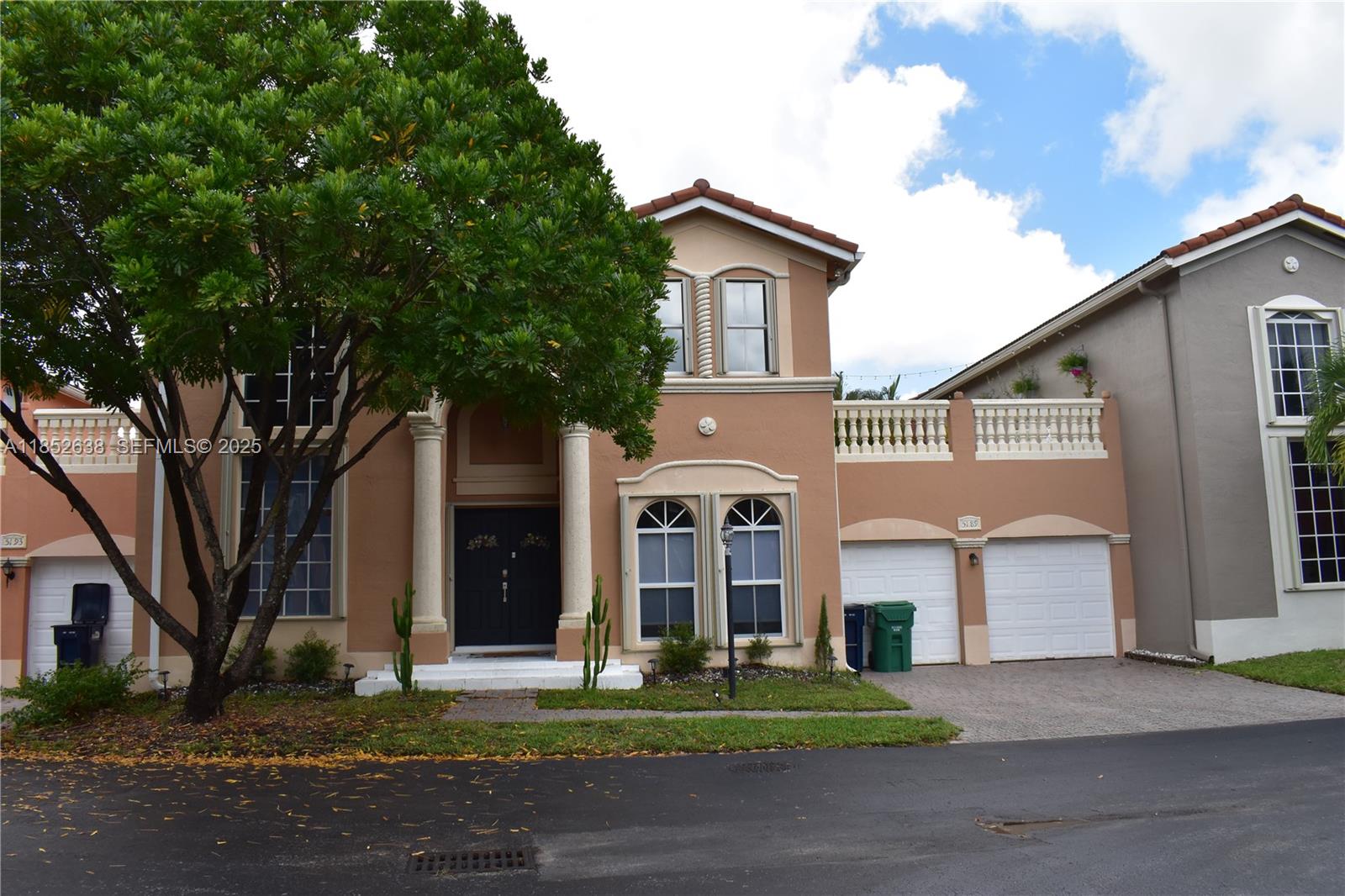 a front view of a house with a garden and trees