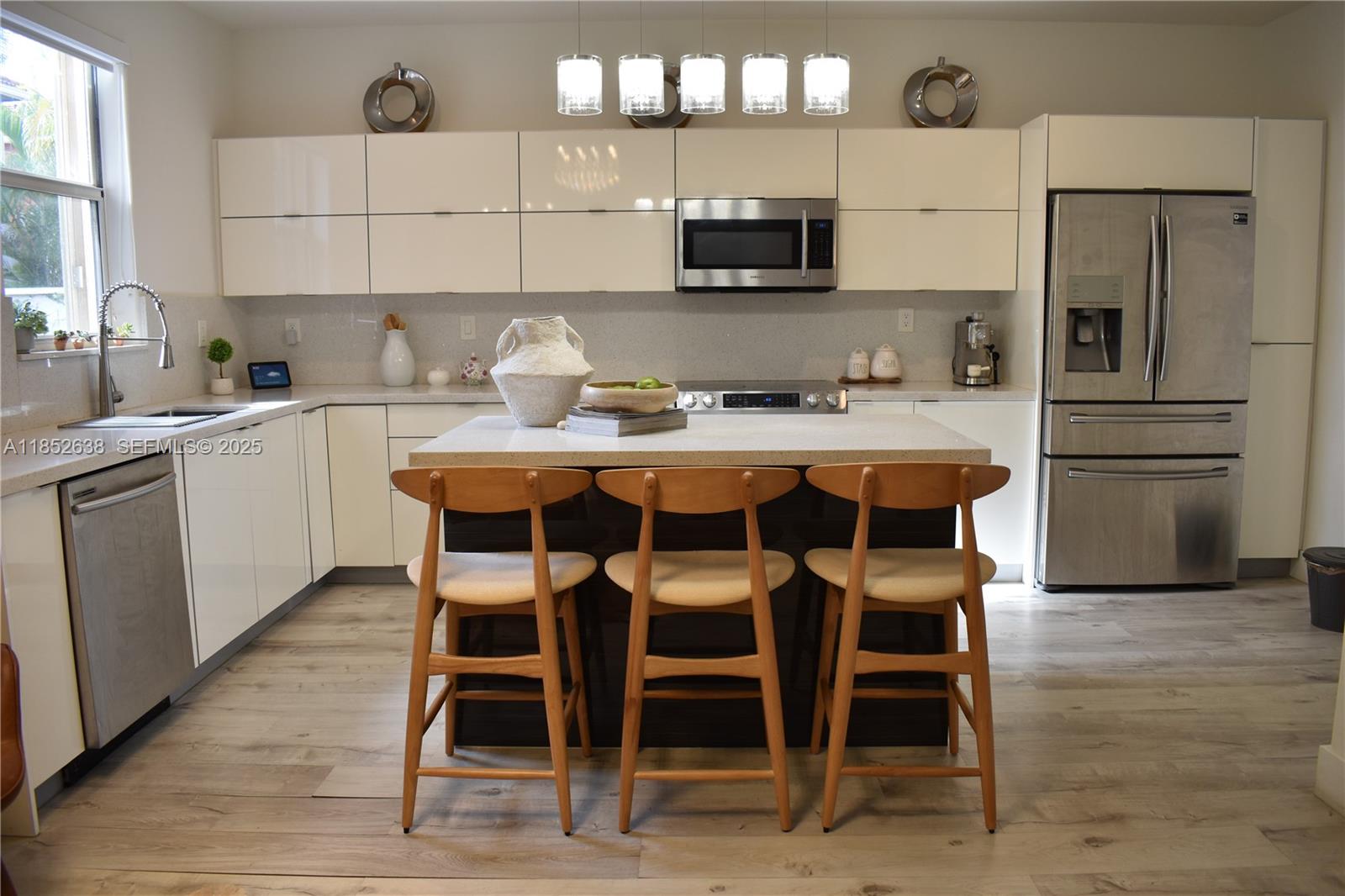 5189 Northwest 108th Path Doral, FL 33178 - Photo 2 of 23 a kitchen with stainless steel appliances granite countertop a table chairs sink and cabinets