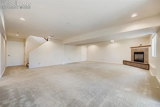 an empty room with a fireplace and cabinet