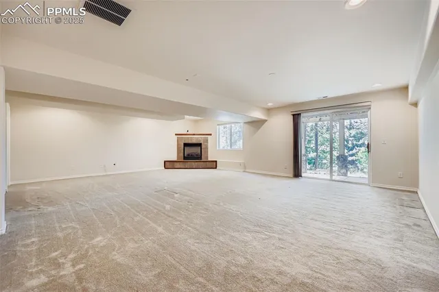 a view of empty room with a window and a fireplace
