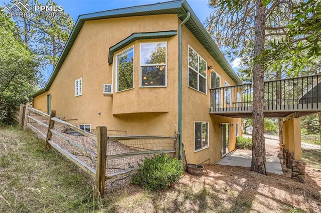 a view of a house with wooden fence next to a road