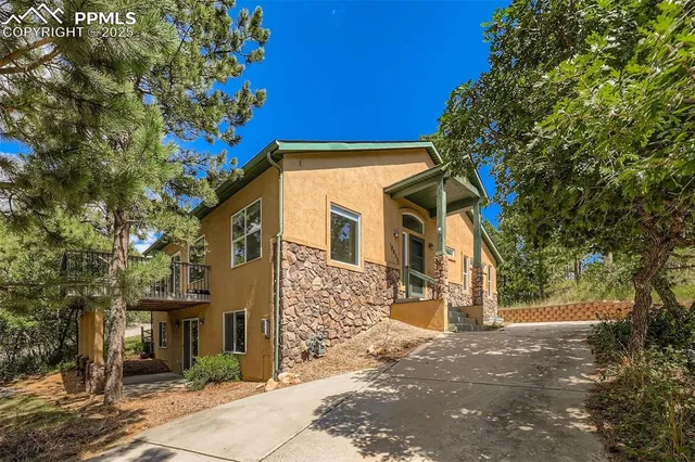 a front view of a house with a tree