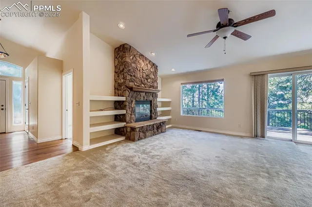 a view of empty room with windows and ceiling fan