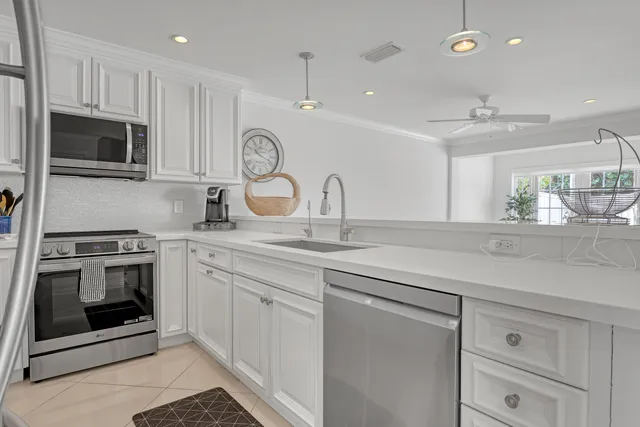 a kitchen with stainless steel appliances a refrigerator sink and microwave
