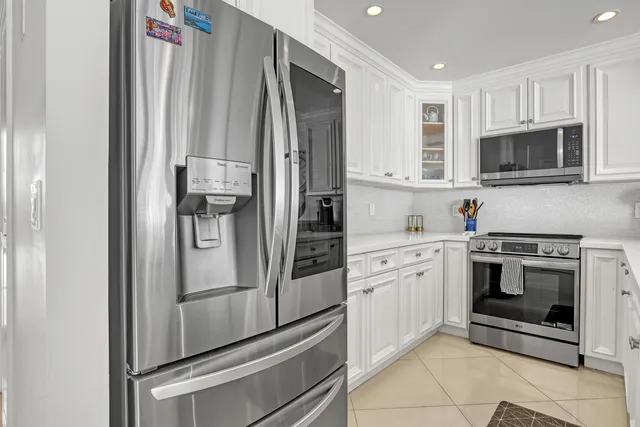 a kitchen with a sink white cabinets and appliances