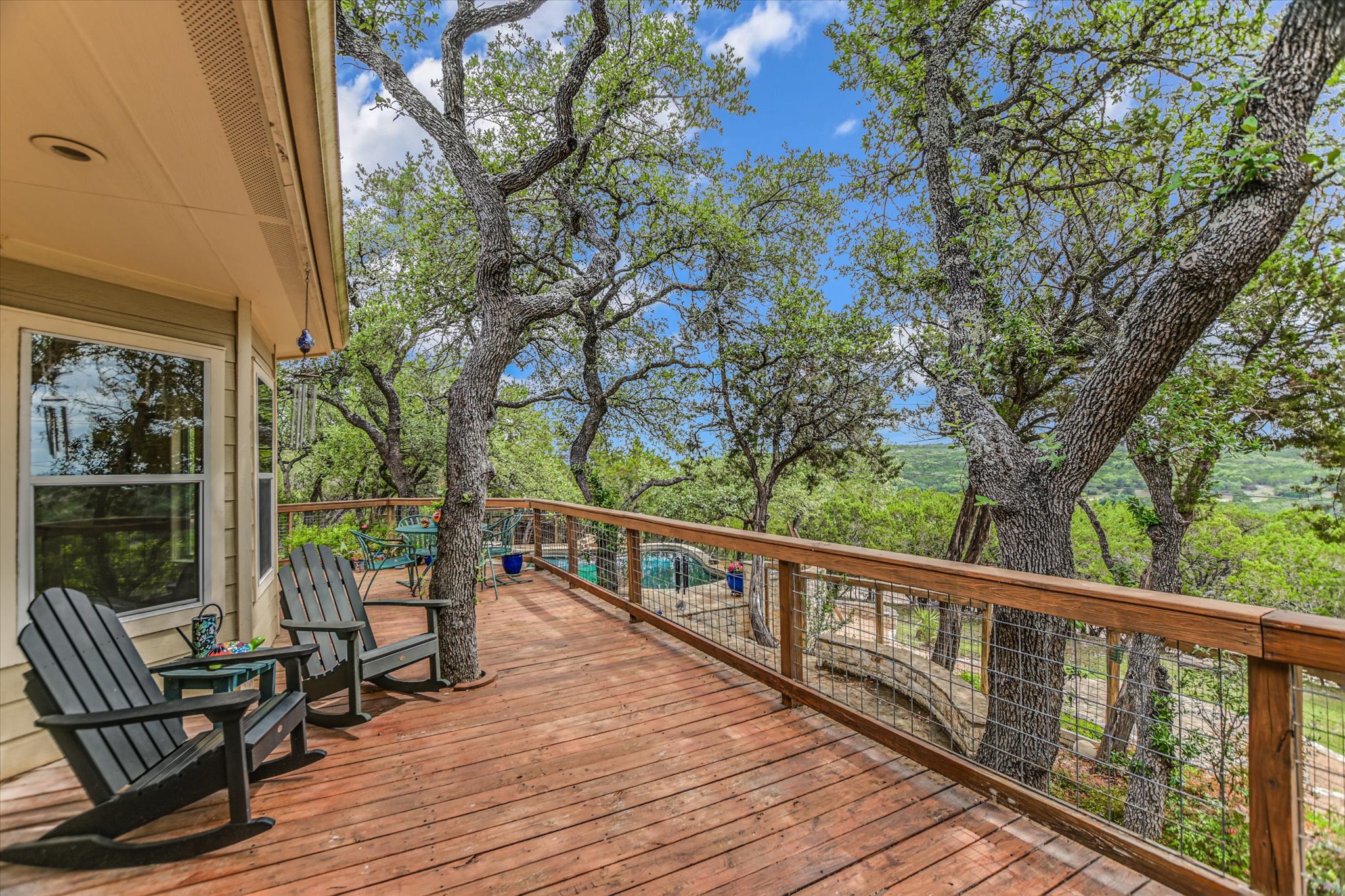 590 Rancho Grande Drive Wimberley, TX 78676 - Photo 24 of 30 a view of a balcony with chairs and wooden fence