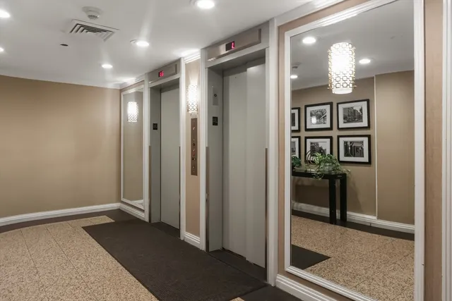 a view of a hallway with wooden floor and cabinet