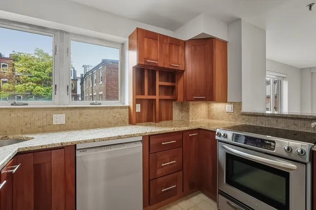 a kitchen with granite countertop a stove a sink and a microwave