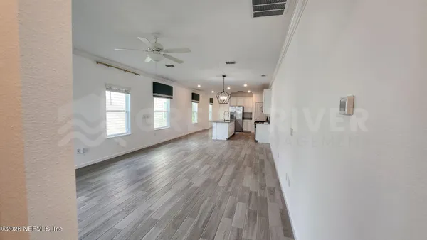 a view of a hallway with wooden floor and stairs