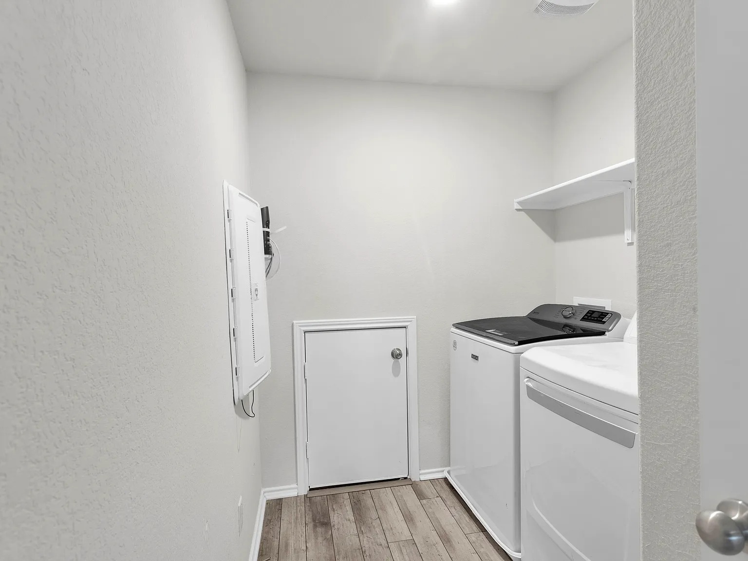 156 Janice Road Taylor, TX 76574 - Photo 13 of 29 Washroom with baseboards, electric panel, light wood-type flooring, laundry area, and washing machine and clothes dryer