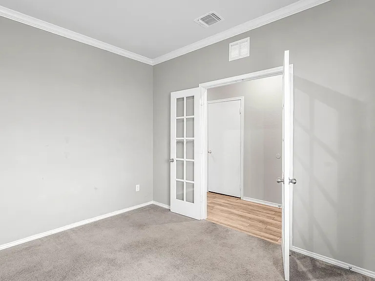 156 Janice Road Taylor, TX 76574 - Photo 4 of 29 Carpeted empty room featuring crown molding, french doors, baseboards, and visible vents