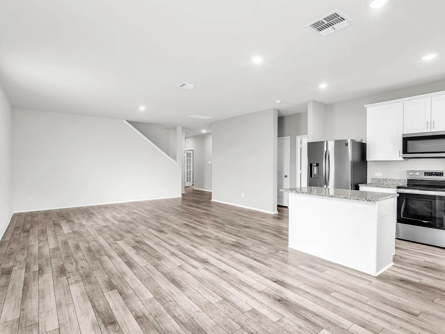 156 Janice Road Taylor, TX 76574 - Photo 6 of 29 Kitchen with light wood-style floors, visible vents, light stone counters, and appliances with stainless steel finishes