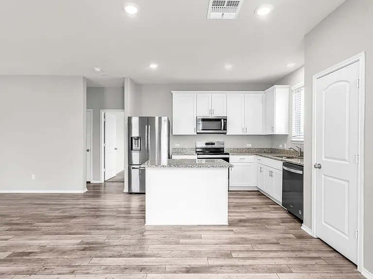 156 Janice Road Taylor, TX 76574 - Photo 7 of 29 Kitchen with visible vents, a center island, a sink, appliances with stainless steel finishes, and light wood finished floors