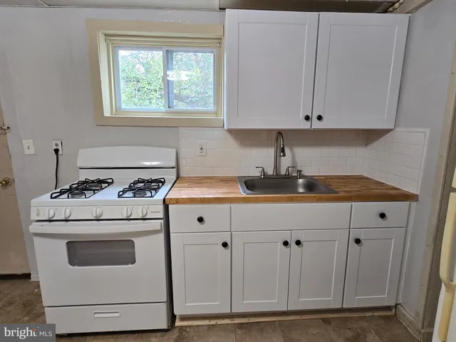 a kitchen with granite countertop white cabinets and white appliances