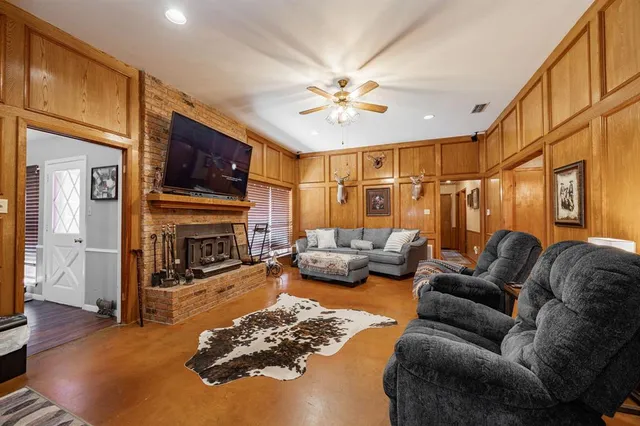 a living room with furniture a fireplace and a flat screen tv