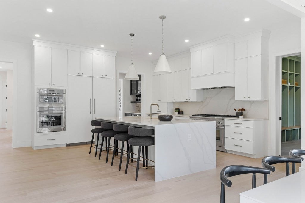 65 Mann Avenue Needham, MA 02492 - Photo 2 of 16 a kitchen with stainless steel appliances kitchen island granite countertop a table chairs sink and cabinets