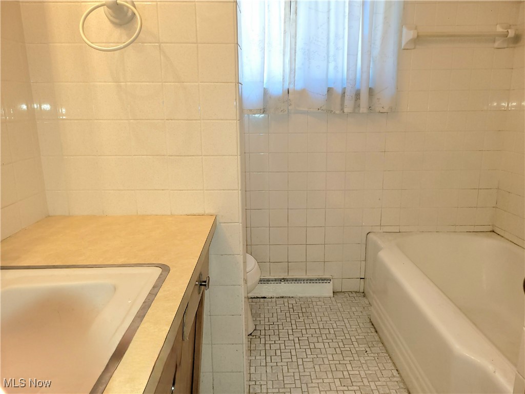 18307 Rosecliff Road Cleveland, OH 44119 - Photo 16 of 41 1st Floor tub with ceramic flooring and tile