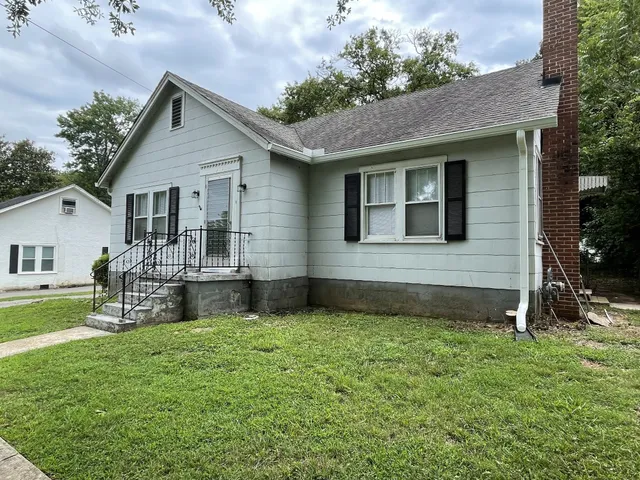 a view of a house with a yard and sitting area