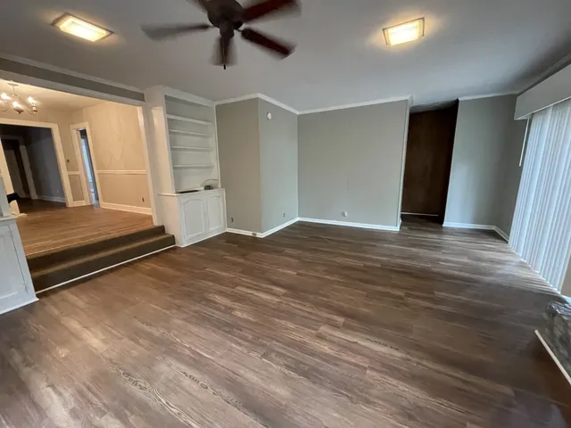 a view of empty room with wooden floor