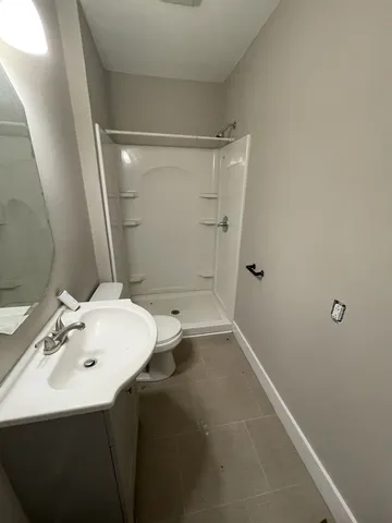 a bathroom with a sink a toilet and shower