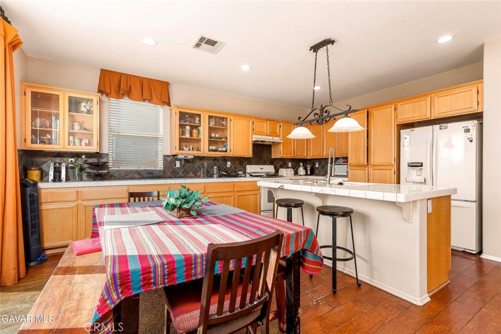 2158 Cypress Street Lancaster, CA 93535 - Photo 12 of 28 a kitchen with stainless steel appliances granite countertop a stove a sink dishwasher and a refrigerator with wooden floor