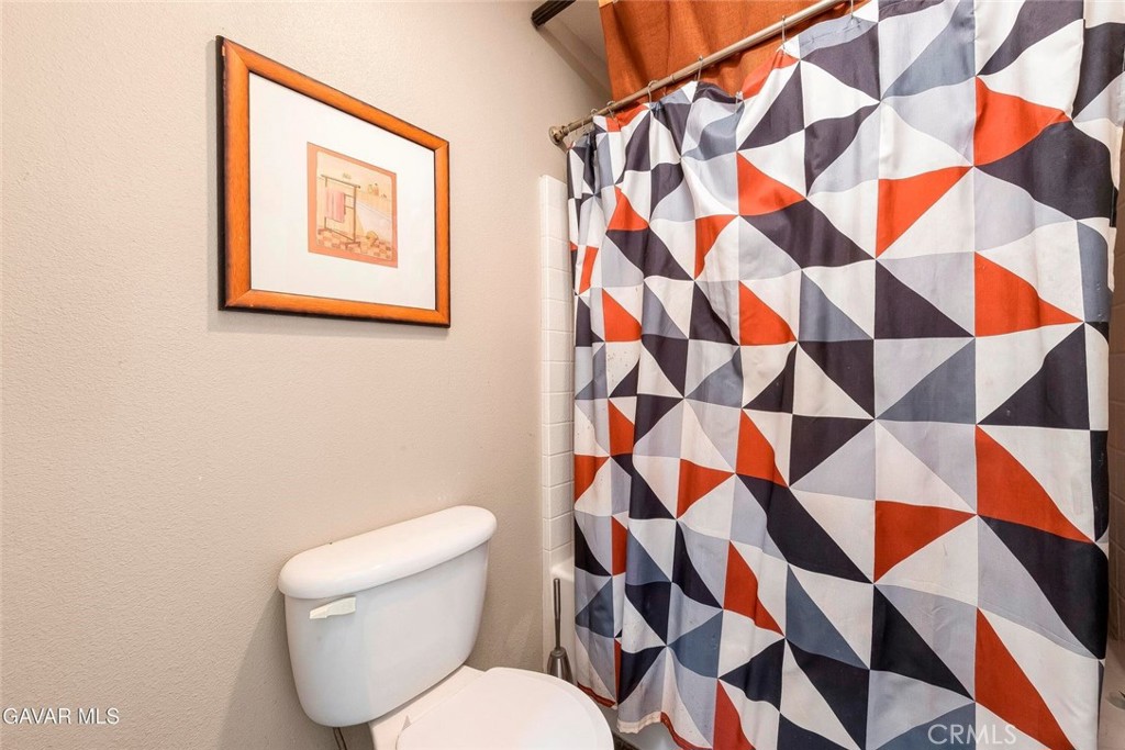 2158 Cypress Street Lancaster, CA 93535 - Photo 17 of 28 a white toilet sitting next to a shower curtain