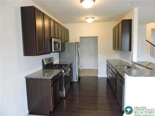 a kitchen with stainless steel appliances granite countertop a stove a sink and a refrigerator