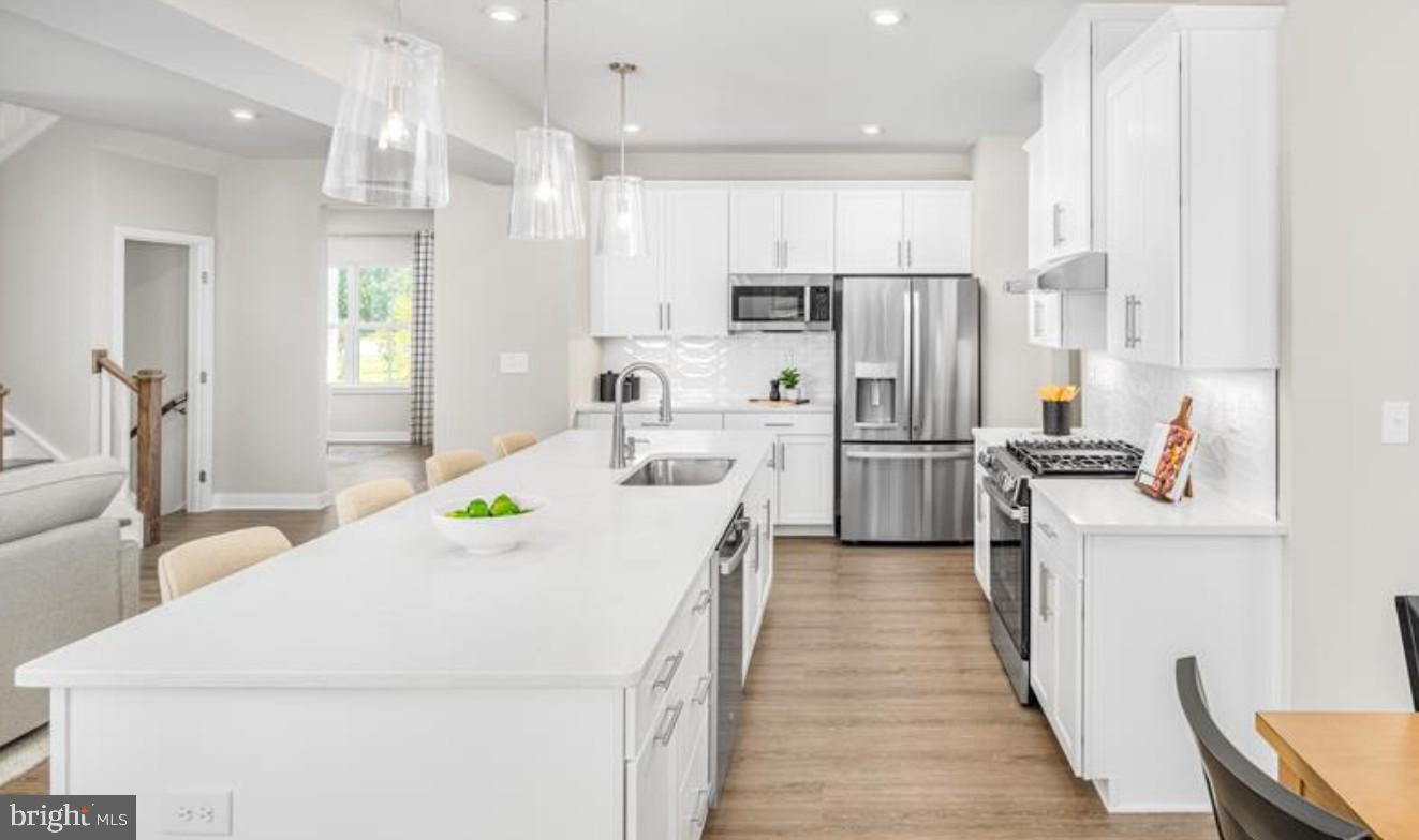 1410 Leeland Forest Road, Unit 25 Upper Marlboro, MD 20774 - Photo 3 of 21 a kitchen with kitchen island a counter top space a sink stainless steel appliances and cabinets
